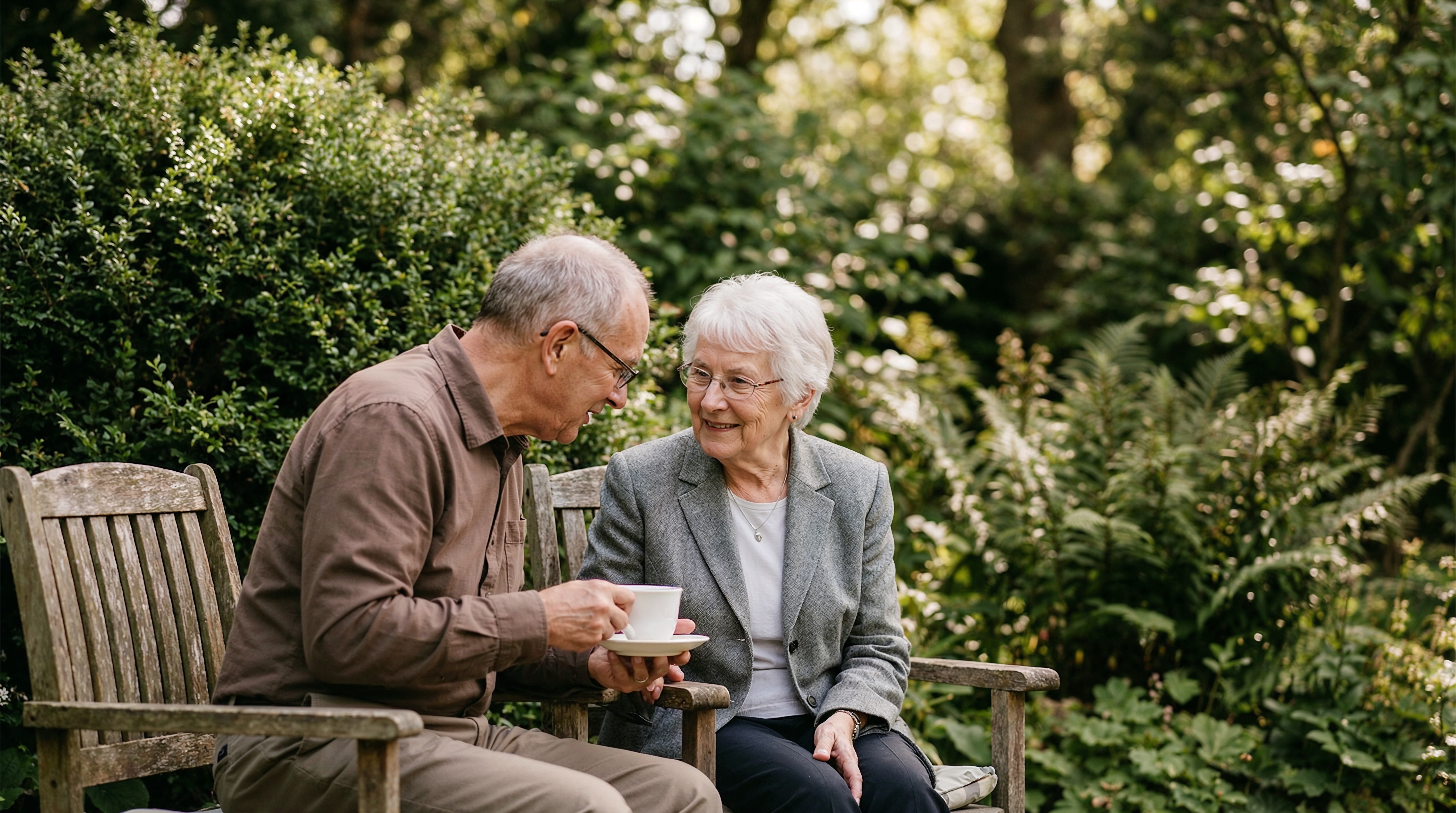 Un couple de retraités discute en prenant le thé dans un jardin