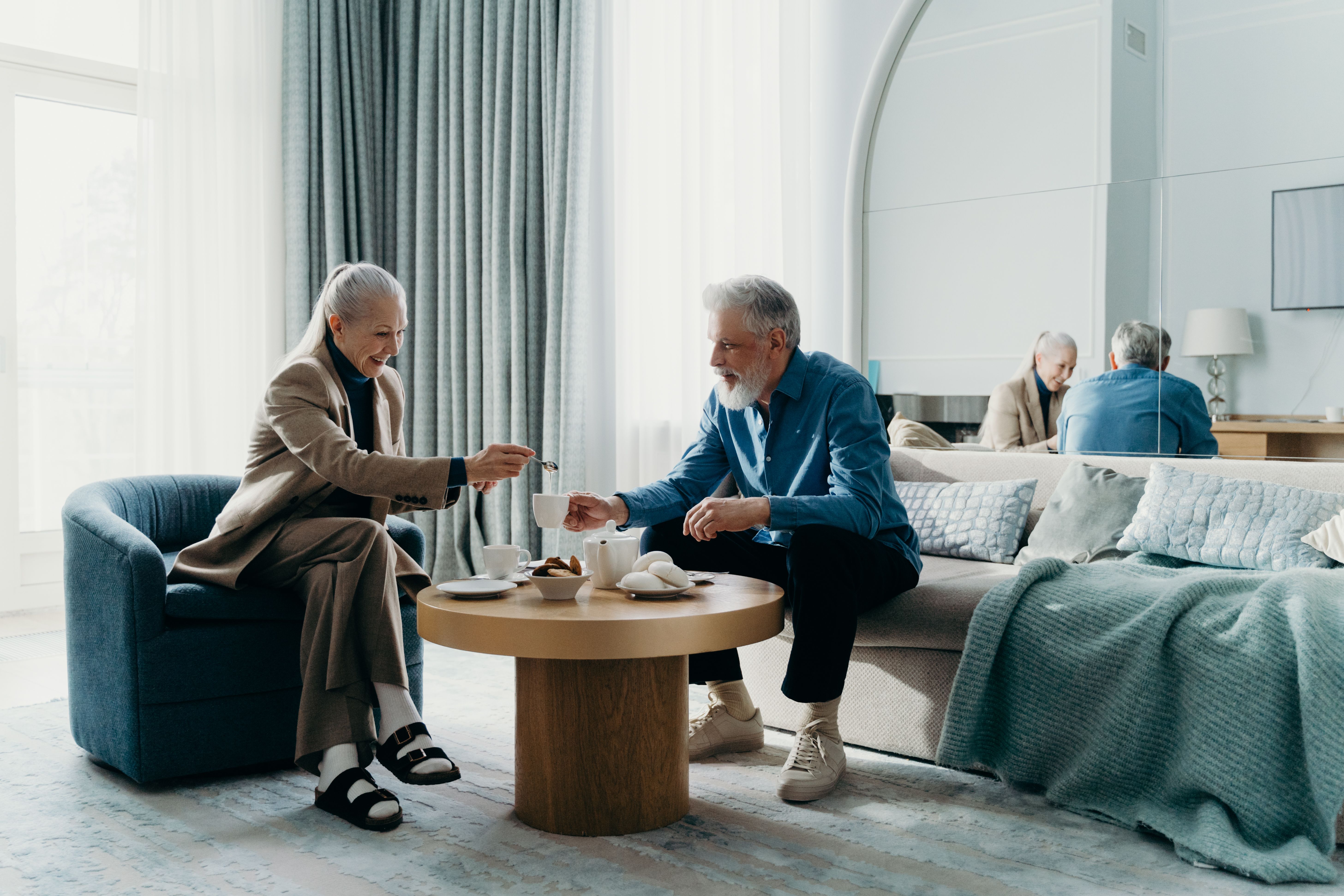 Un couple de seniors partage un moment convivial autour d'une table basse dans leur salon